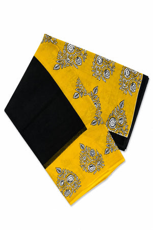 A folded yellow and black saree with ornate black and white floral patterns.