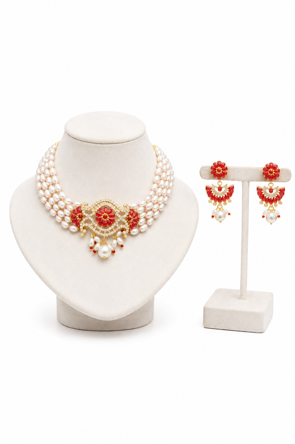 A traditional Indian jewelry set featuring a pearl and red stone choker necklace, alongside matching red and pearl dangle earrings.