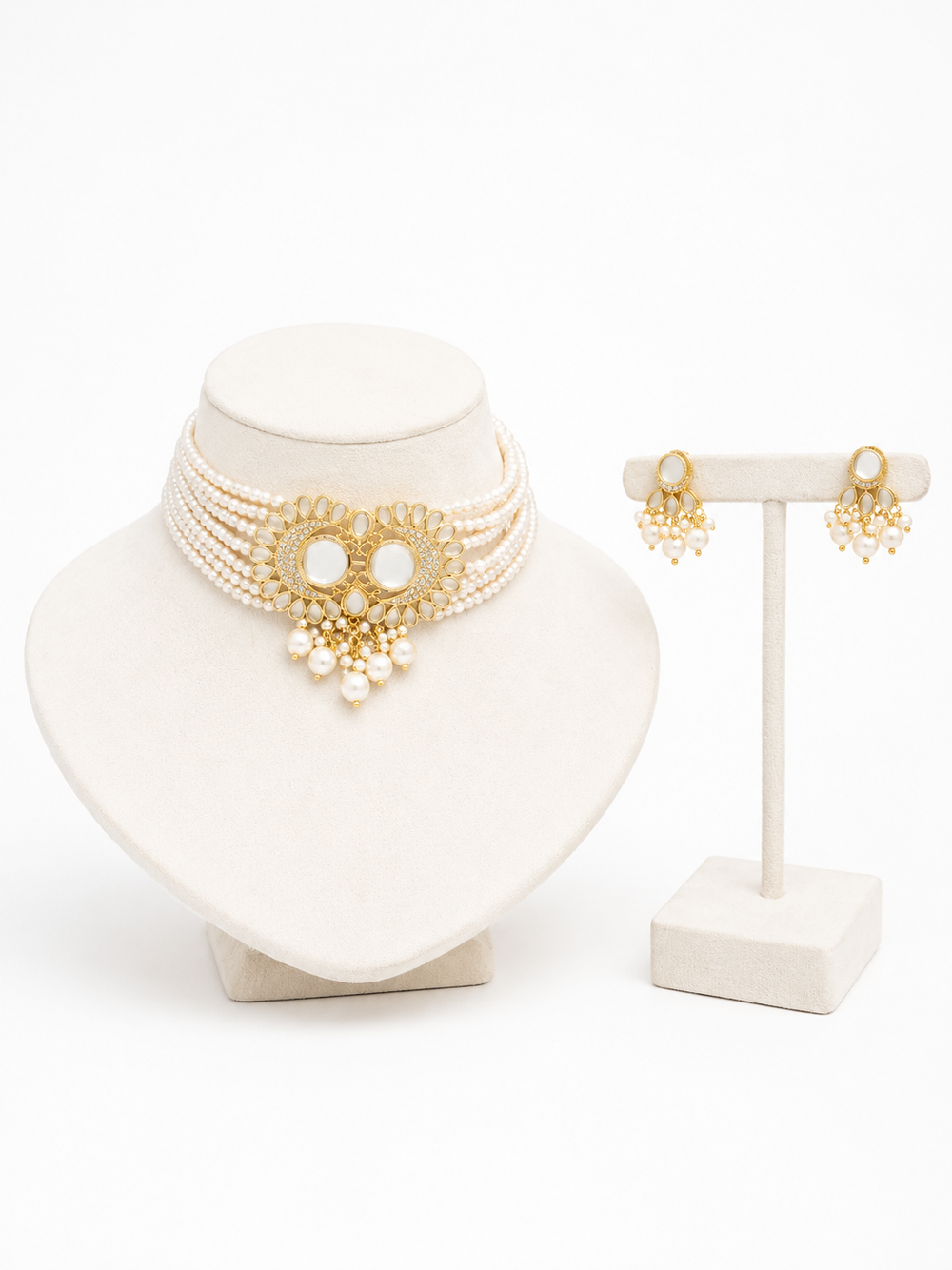A gold and pearl jewelry, featuring a multi-strand choker necklace with a central ornate gold medallion and dangling pearls, alongside matching drop earrings.