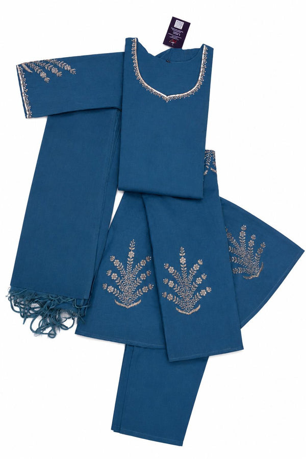 A folded blue traditional outfit set with matching pants and a fringed dupatta, featuring silver embroidered patterns on the neckline and fabric.