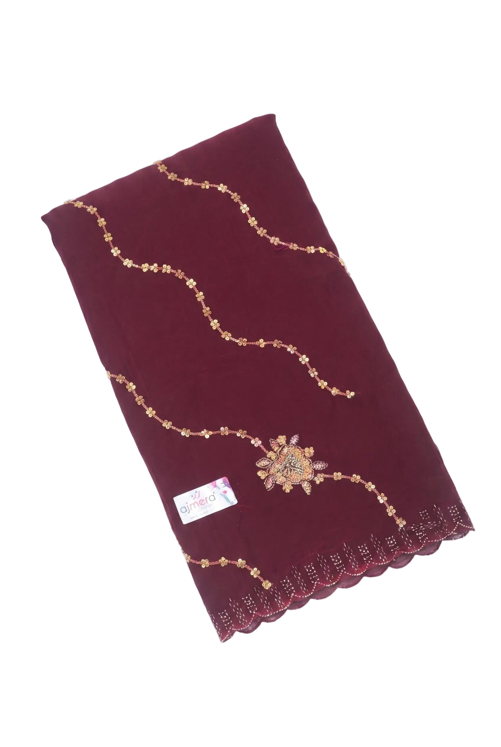 A woman models a deep maroon/burgundy saree with gold zari embroidery. The saree features a solid body, a draped pallu, and scalloped edges with embroidered details.