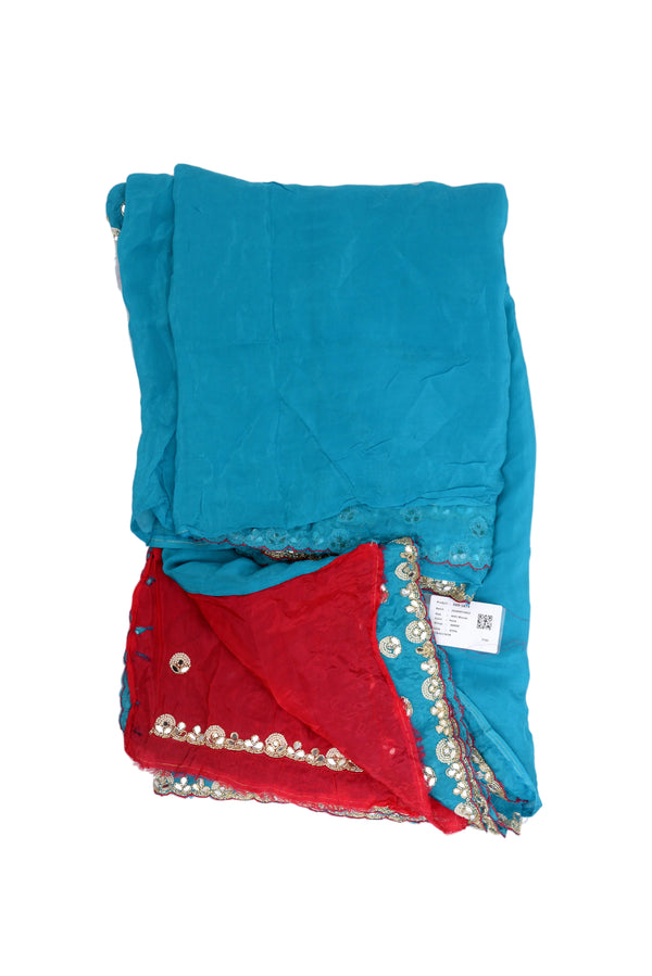A folded teal blue saree showing decorative silver embroidered borders.
