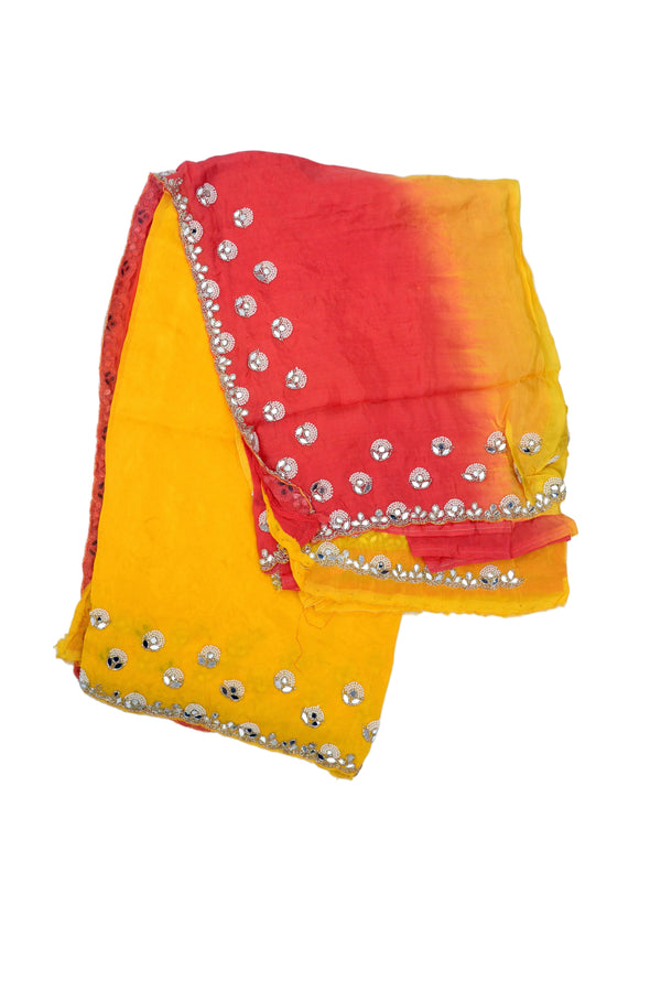 A folded yellow and red gradient saree decorated with rows of silver rhinestone borders 
