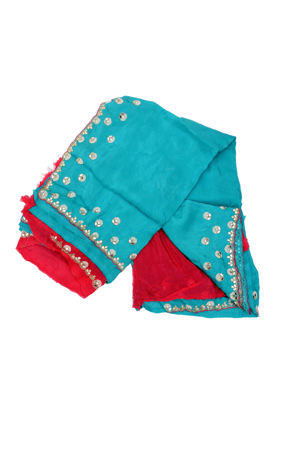 A woman modeling a teal blue saree with a deep red sleeve and gold mirror work borders, posed against a solid brown studio backdrop.