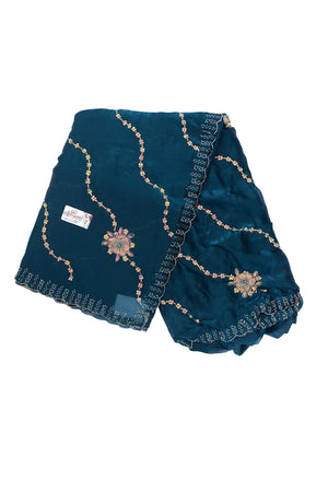 A dark teal blue saree with gold and silver embroidered floral patterns and scalloped borders, displayed on a white background.