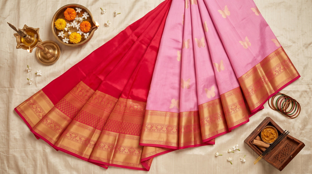 A woman models a vibrant pink silk saree with intricate gold zari woven patterns and borders.