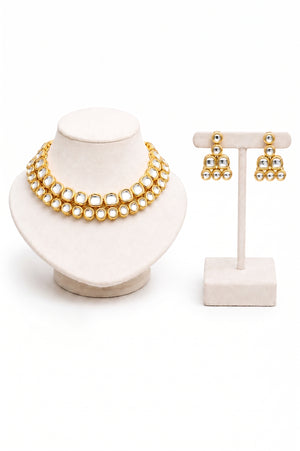Gold jewelry set featuring a double-strand necklace and matching earrings with clear stones.