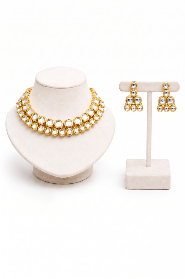 Gold jewelry set featuring a double-strand necklace and matching earrings with clear stones.