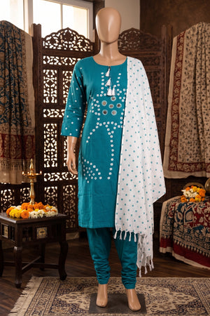A teal and white ethnic three-piece suit includes a teal kurta with white geometric embroidery, matching teal pants, and a white dupatta with blue polka dots and tassel fringe.
