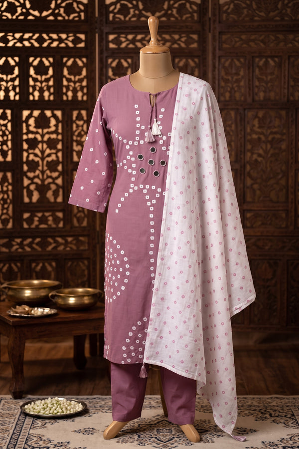 A three-piece Indian ethnic suit, featuring a dusty purple kurta with white mirror print, matching purple pants, and a white dupatta with pink floral prints.