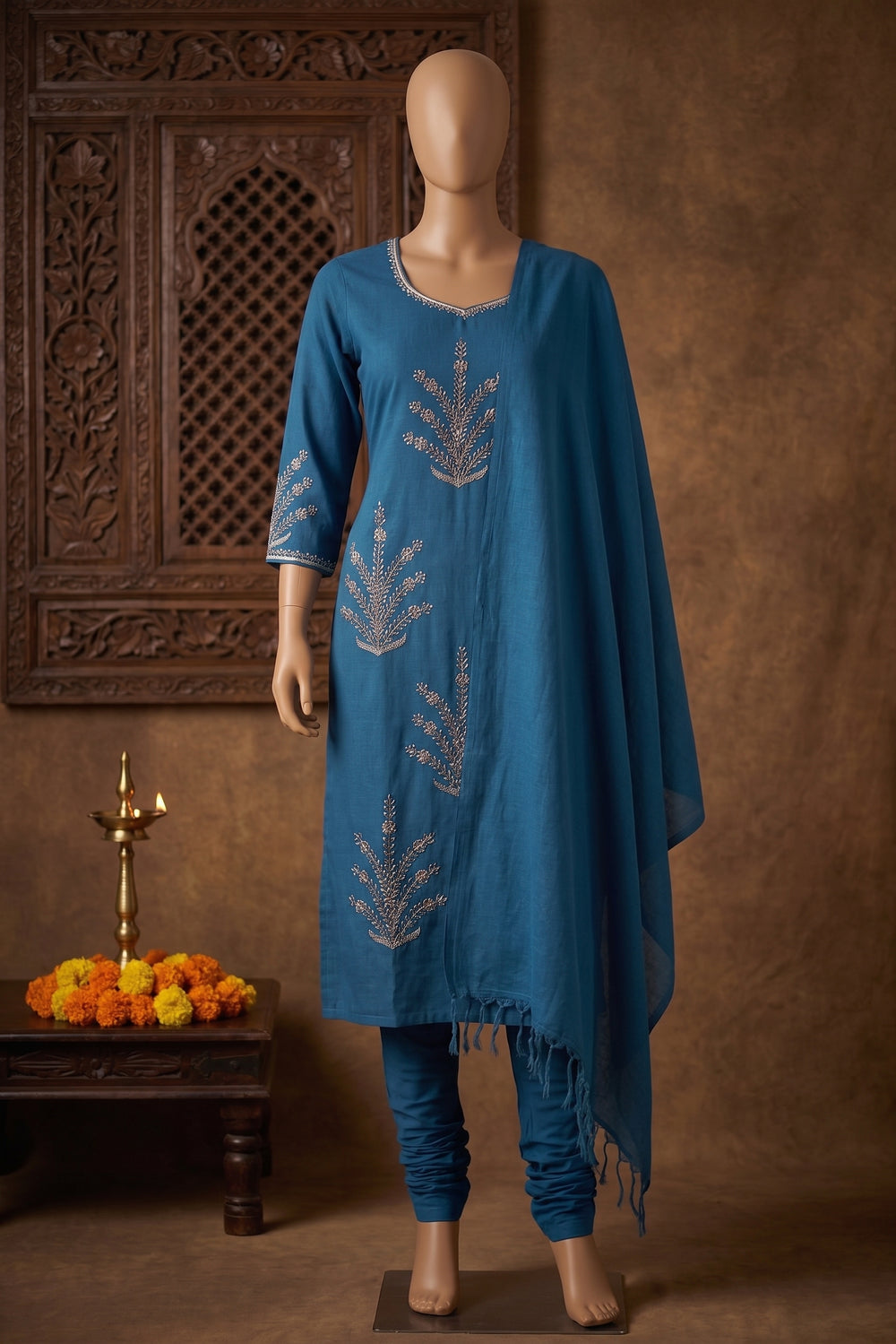 A woman modeling a blue three-piece Indian ethnic suit set with matching pants and a dupatta, featuring silver embroidery.