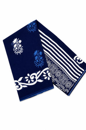 A folded navy blue saree, featuring white and light blue block-print patterns, including floral motifs, stripes, and a decorative border.
