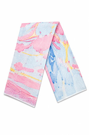 A folded saree featuring a colorful abstract watercolor paint design in pink, light blue, and yellow.