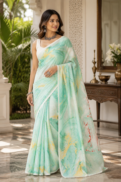 A woman model with a light green border and a marbled print of yellow, red, and green saree. 