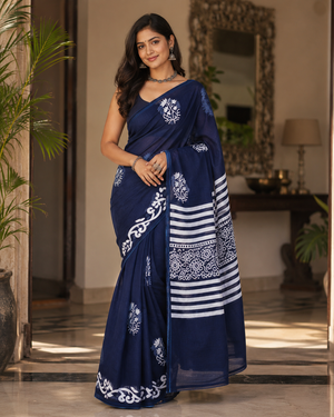 A woman modeling a navy blue saree with white floral and striped patterns.