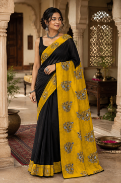 A woman models a black and mustard yellow saree with white block-printed motifs.